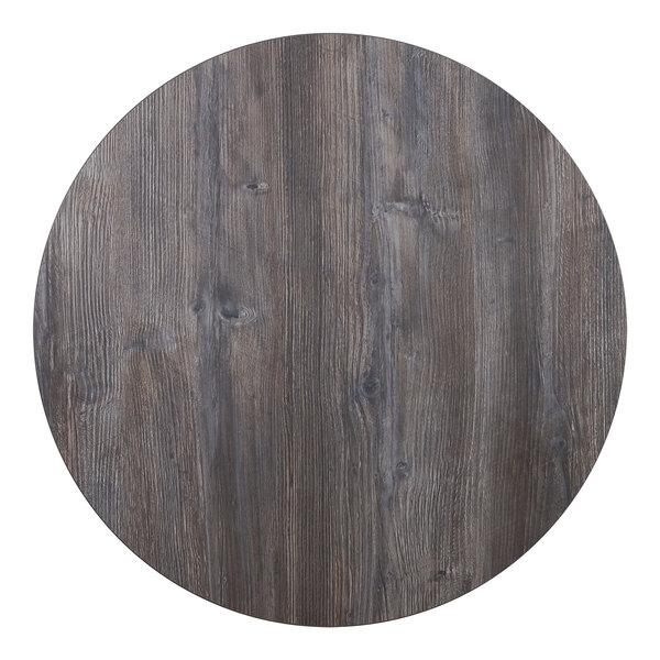 A BFM Seating Midtown round wooden table top with a dark gray finish.