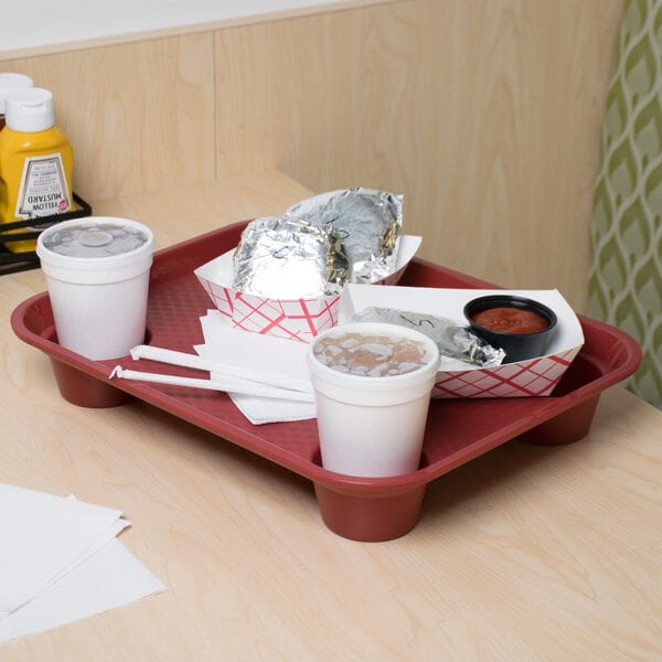 A red GET fast food tray on a table with food and a white cup with a drink in it.