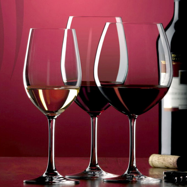 Three Stolzle Classic burgundy wine glasses filled with red wine.
