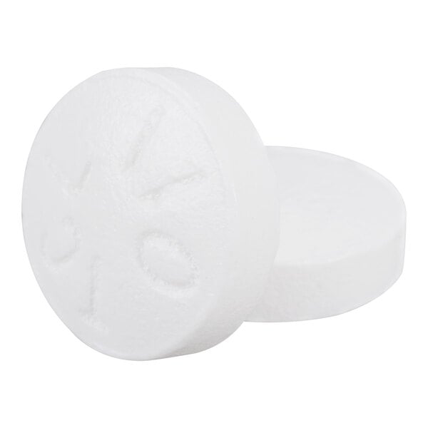 Two round, white tablets with a scored line and some embossed markings on the surface.