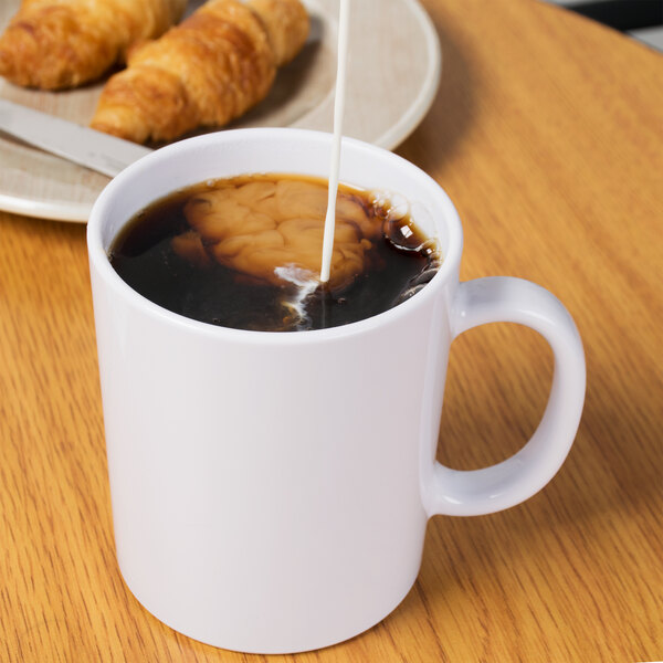 A white GET Tritan Mug filled with coffee and milk.