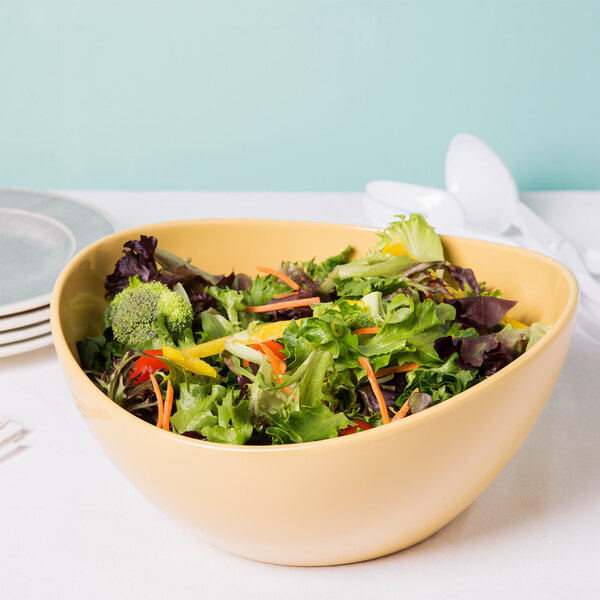 A GET Osslo Dijon melamine bowl filled with salad on a table.
