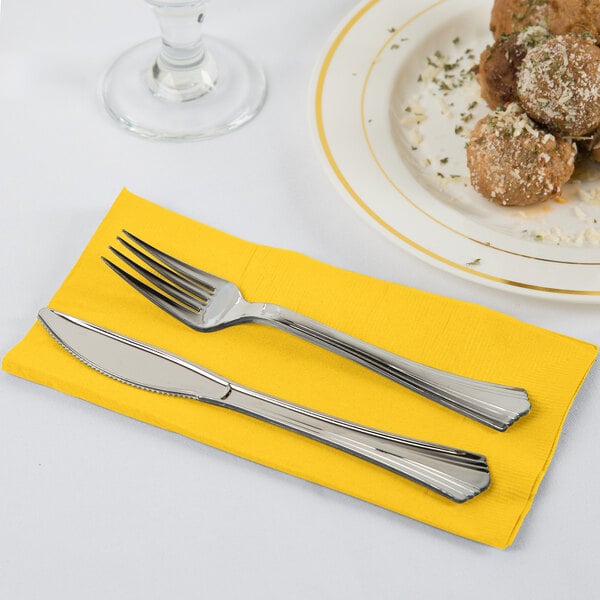 A knife and fork on a School Bus Yellow paper napkin.