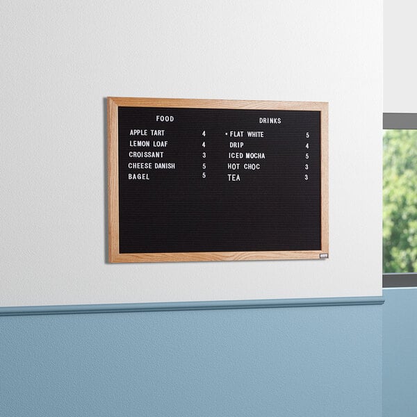 A black Aarco felt message board with white text on it.