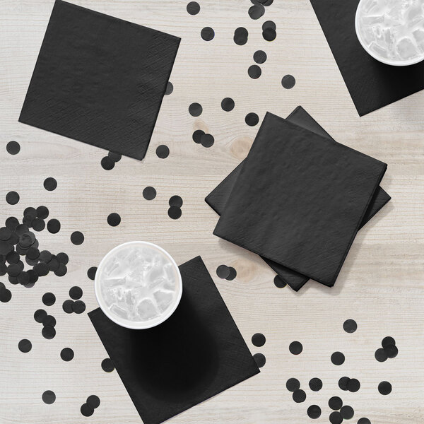 A black napkin with ice on a white table.