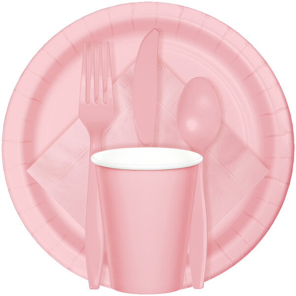 A pink box with a white stripe containing a pack of Classic Pink Creative Converting paper dinner napkins.