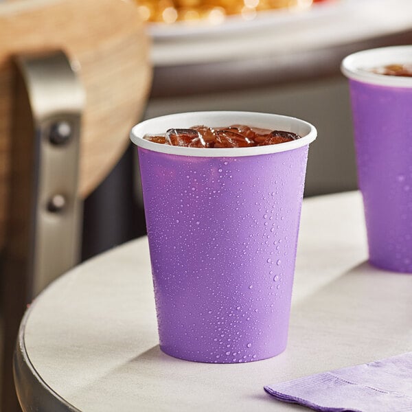 A purple Creative Converting paper cup with ice on a table.