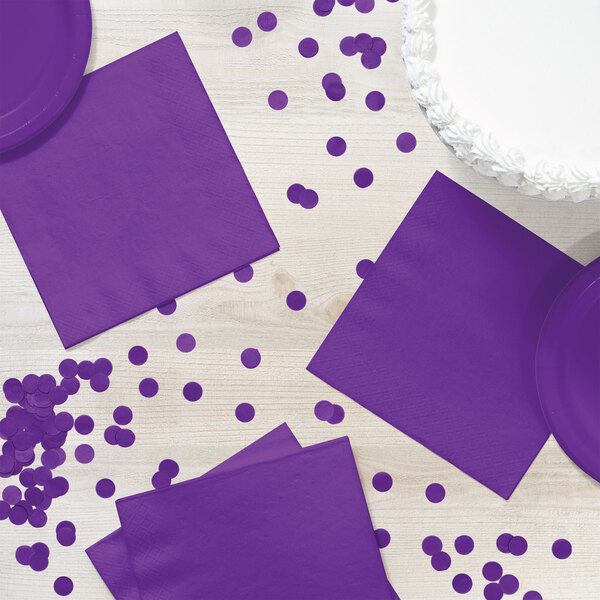 A purple napkin on a table with confetti.