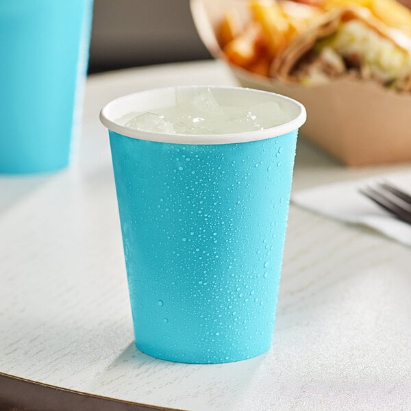 A Bermuda blue Creative Converting paper cup with ice in it.