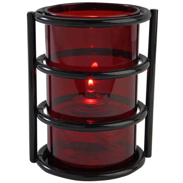 A Sterno red glass candle holder with a flame in it.