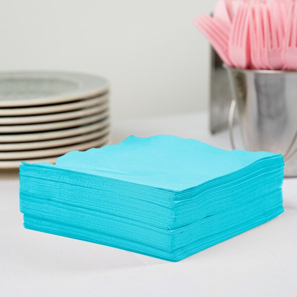 A stack of Bermuda Blue paper napkins on a table.