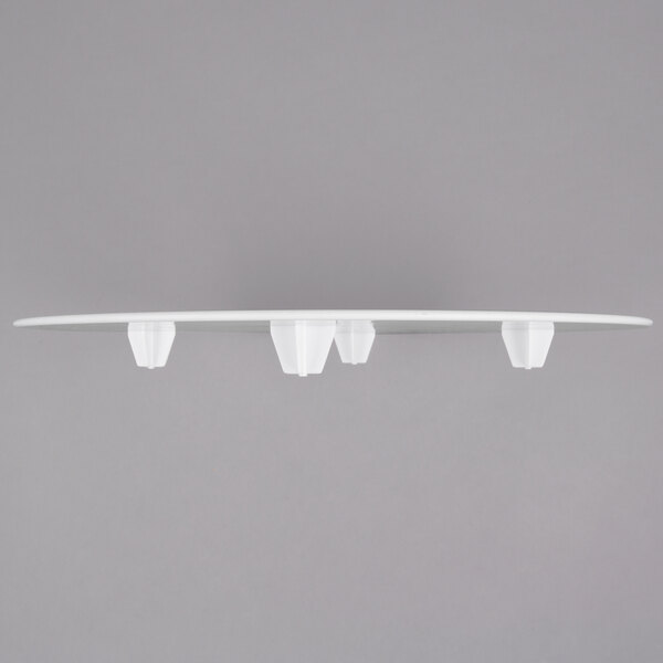 A white Wilton cake separator plate with four holes.