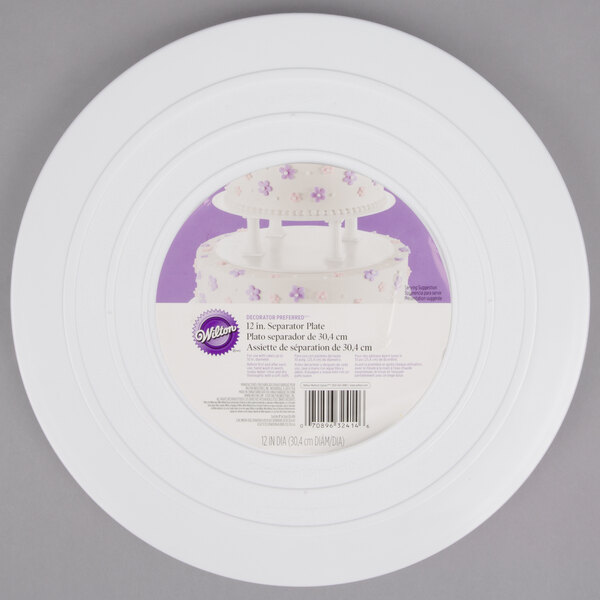 A white Wilton round cake separator plate with a cake on it.