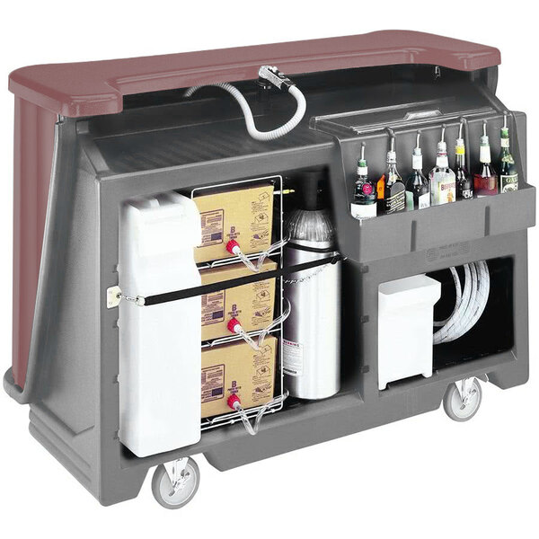 A brown Cambro portable bar with bottles and boxes on it.
