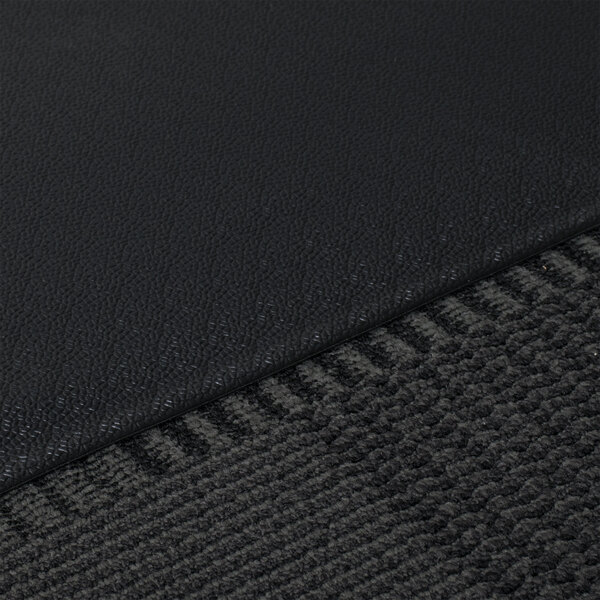 A close up of a black carpet with a gray underside.