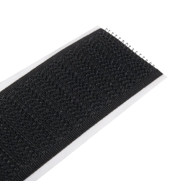 A black velcro strip on a white surface.