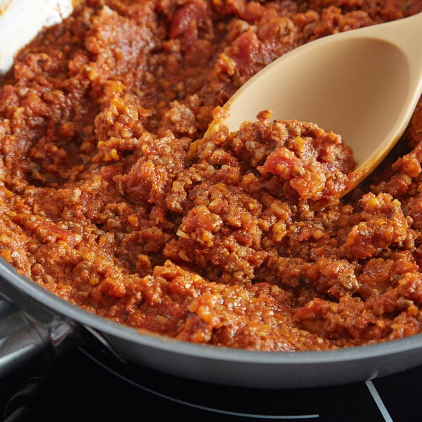 A spoon stirring a pot of minced onion.