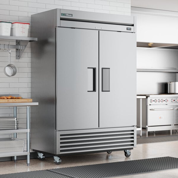 A True T-49F-HC reach-in freezer with two solid doors in a professional kitchen.