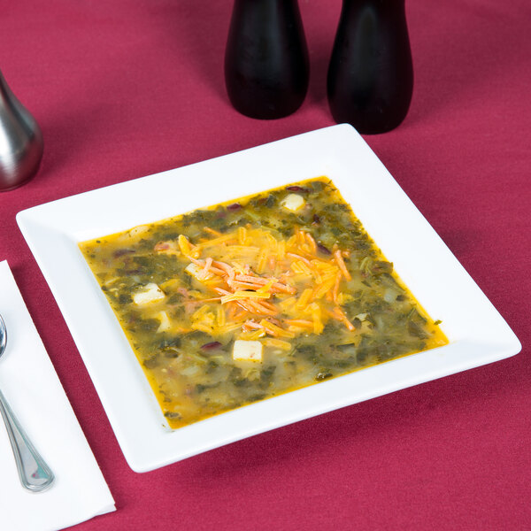 A Libbey Ultra Bright White porcelain soup bowl filled with soup, cheese, and vegetables.