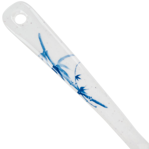 A close-up of a Thunder Group Blue Bamboo Melamine Soup Ladle with a white and blue handle with blue leaves.