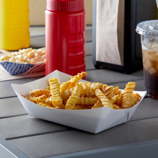 A white paper food tray filled with french fries on a table in a food truck.