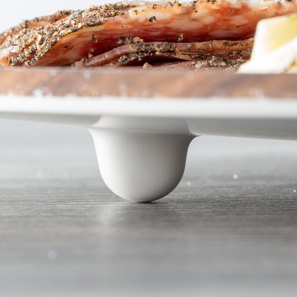 An American Metalcraft faux acacia melamine serving board with food on it.