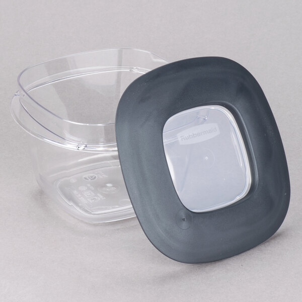 A clear plastic Rubbermaid square container with a black lid.