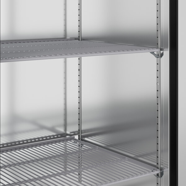 A metal shelf in a True stainless steel reach-in refrigerator.