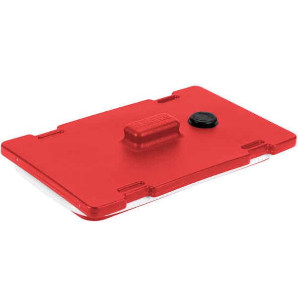 A red plastic Camtainer lid with a black button.