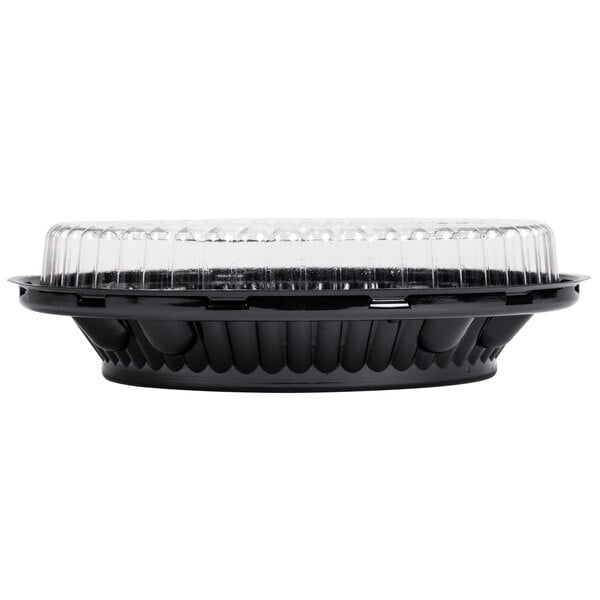 A close-up of a D&W Fine Pack black plastic pie container with clear low dome lid.
