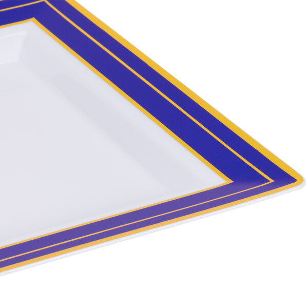 A close up of a Fineline square white plastic plate with blue and gold stripes.