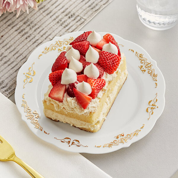 A Fineline Heritage plastic plate with a piece of cake topped with strawberries and whipped cream, with a fork.