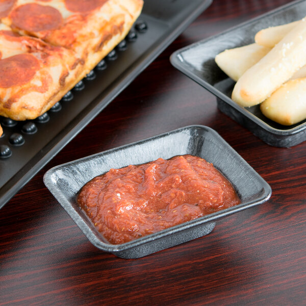 A tray of pizza and HS Inc. rectangular condiment servers with pizza and sauce on a table.