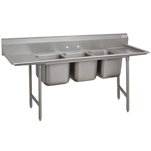 A stainless steel Advance Tabco three compartment pot sink with two drainboards.