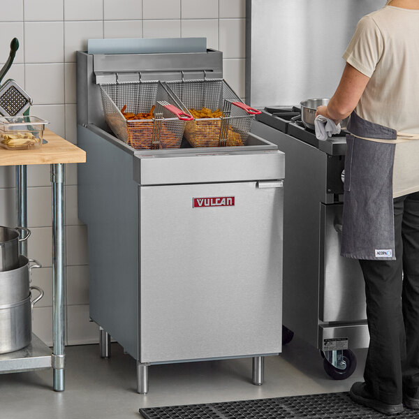 A commercial Vulcan liquid propane floor fryer with two baskets filled with fried food.