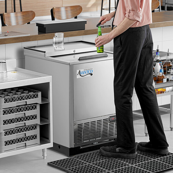 A man standing in front of an Avantco stainless steel glass froster.