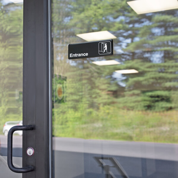 A glass door with a black and white Thunder Group entrance sign.