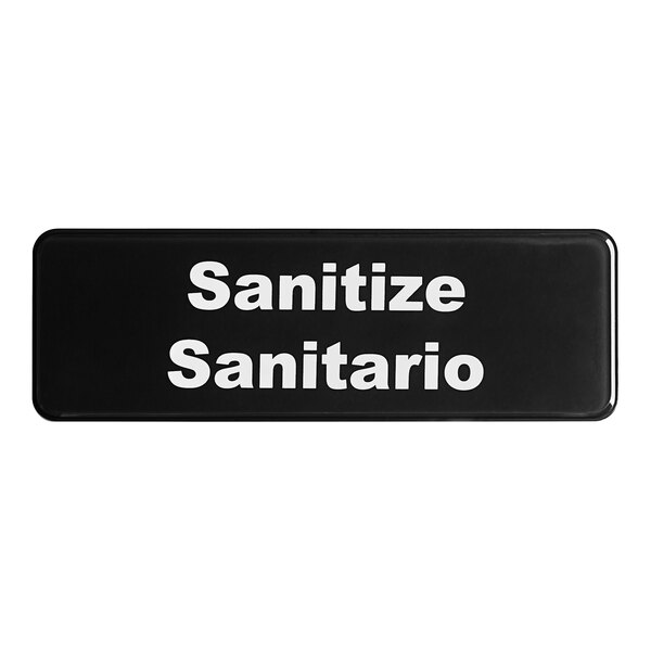 A black Tablecraft sign with white text that says "Sanitario"