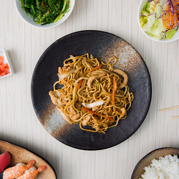 A plate of noodles with meat and vegetables on a 10 Strawberry Street Whittier Nagoya stoneware plate.