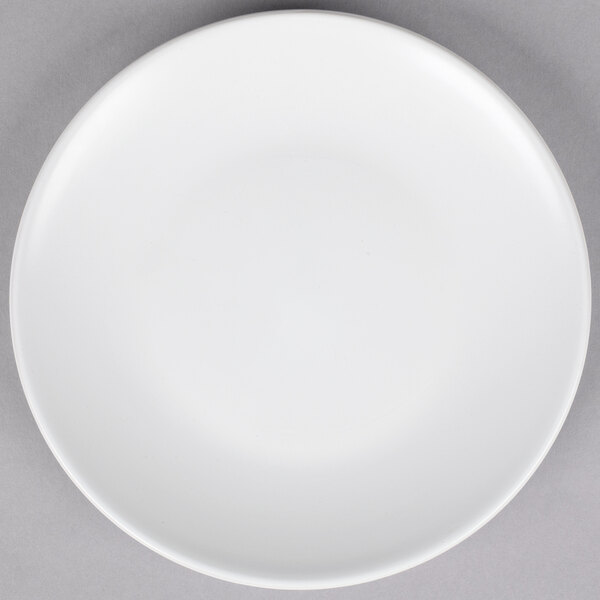 A white 10 Strawberry Street Wazee Matte stoneware salad plate on a gray surface.