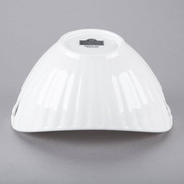 A 10 Strawberry Street Whittier white porcelain boat bowl with line texture on a white surface with light streaks.