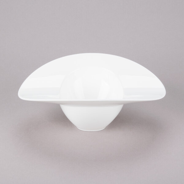 A close up of a white 10 Strawberry Street Somba oval bowl with a curved rim.