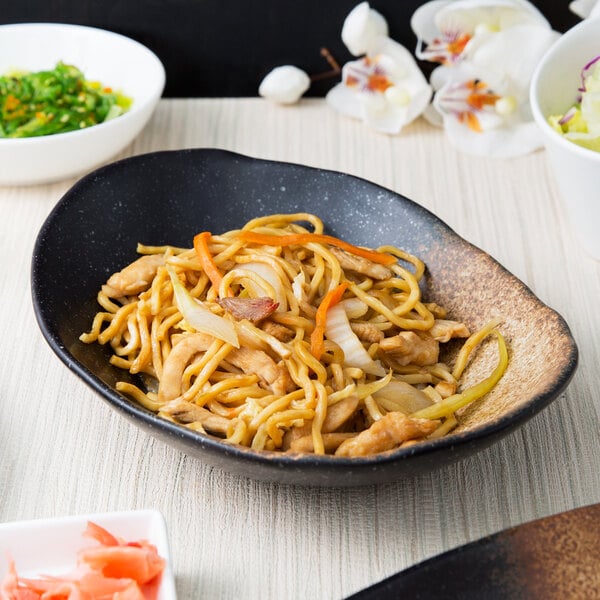 A 10 Strawberry Street Whittier stoneware bowl filled with noodles and vegetables.
