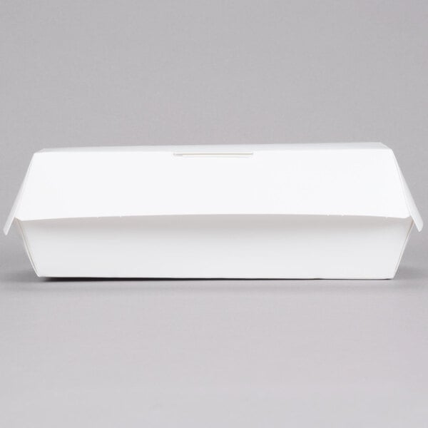 A white paper sandwich clamshell container on a gray surface.