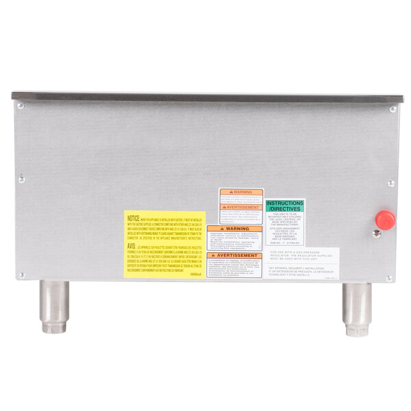 A stainless steel machine with a yellow notice with black text on the back.