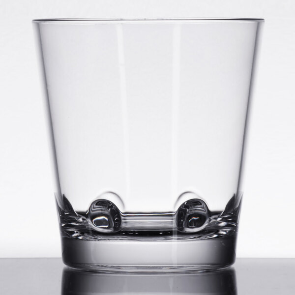 A close up of a clear GET Loft plastic double rocks glass with a small base.