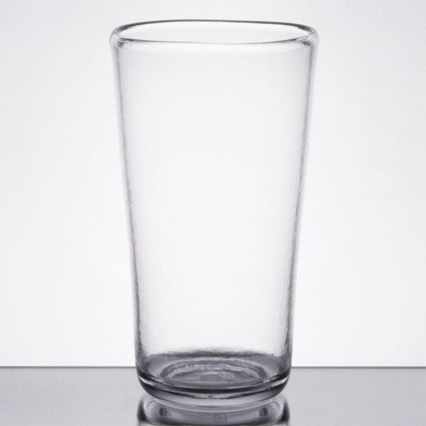 A clear glass cup sitting on a table.