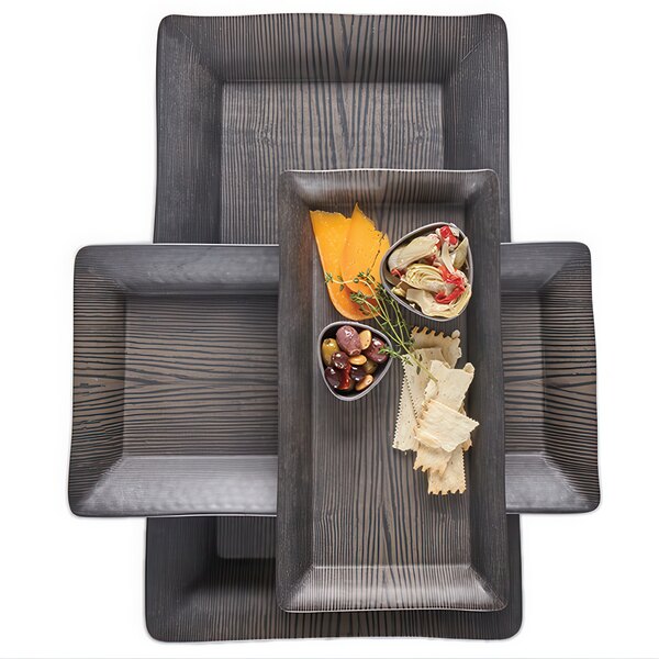 A group of rectangular walnut melamine trays with food on a table.