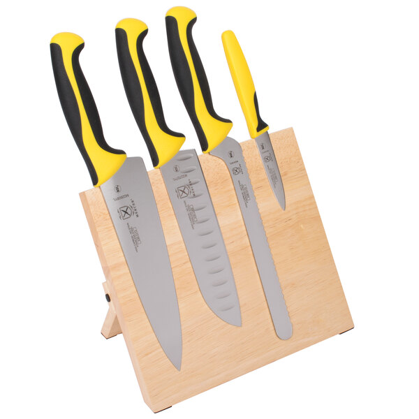 A Mercer Culinary Millennia Colors knife set on a wooden magnetic board.