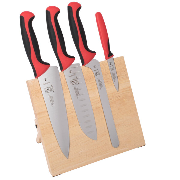 A Mercer Culinary Millennia Colors® knife set with red handles on a wooden block.